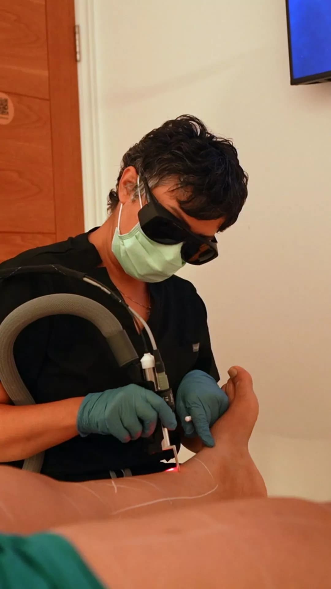 Practitioner in laser goggles giving laser hair removal at Tadore Clinic