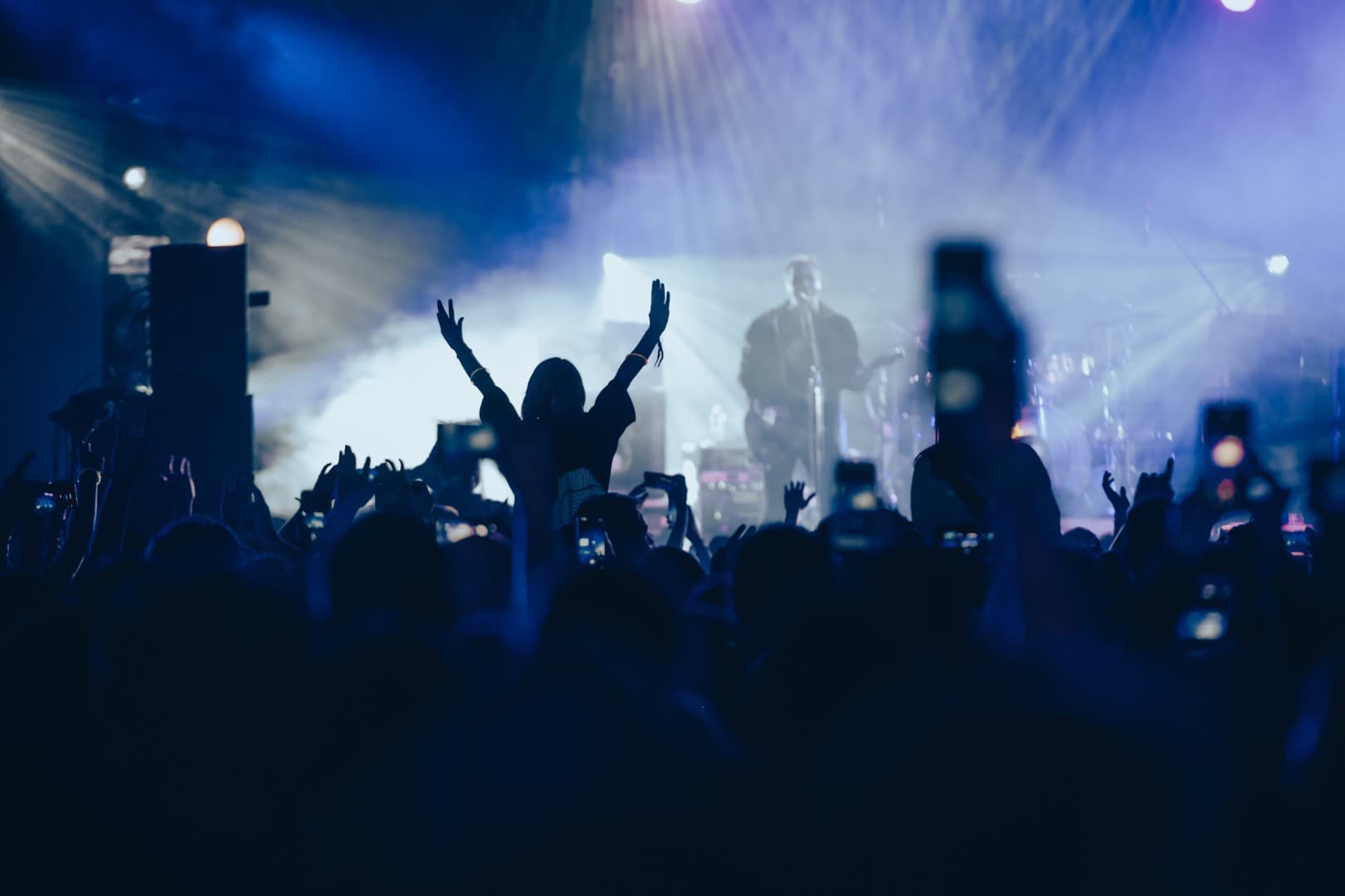 Crowd with raised hands in front of a lit concert stage for Tenor Records