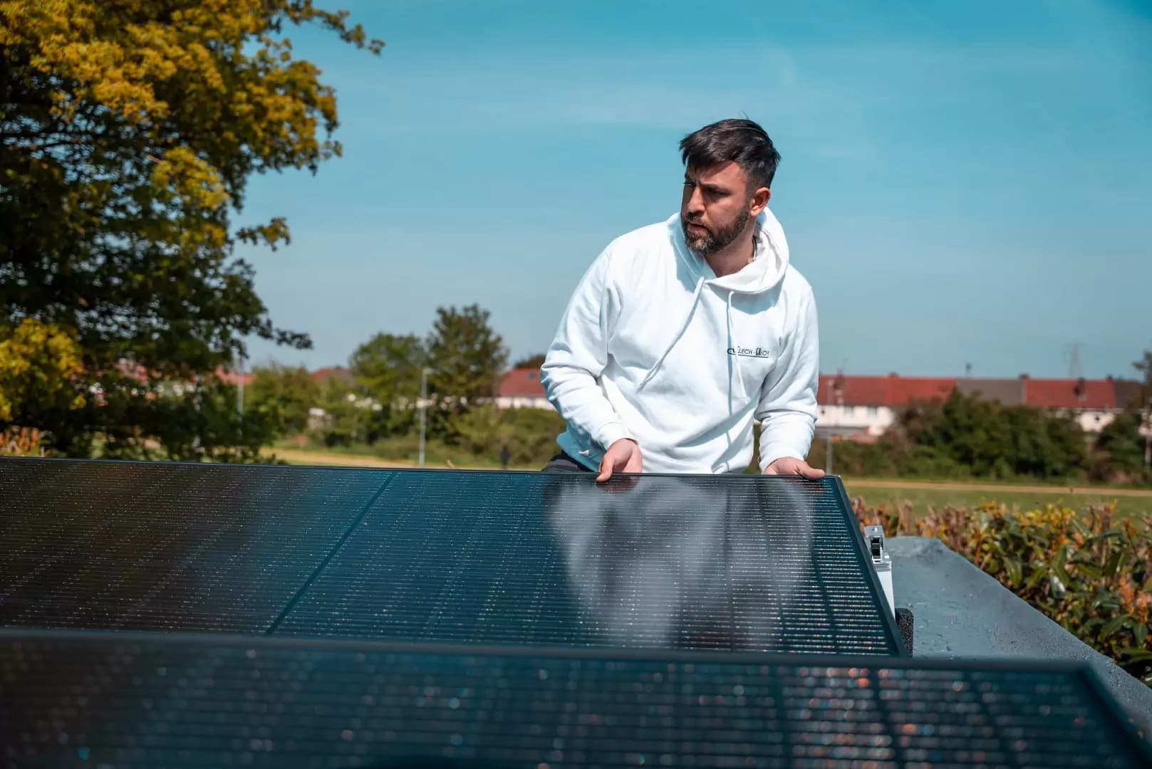 Elech Tech installer inspecting a solar panel outdoors